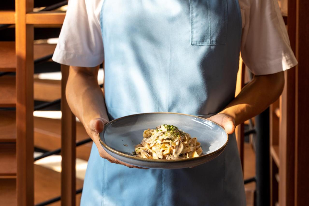 Outrigger Surin Beach Resort - Sha Extra Plus Eksteriør bilde A server holding a plate of pasta